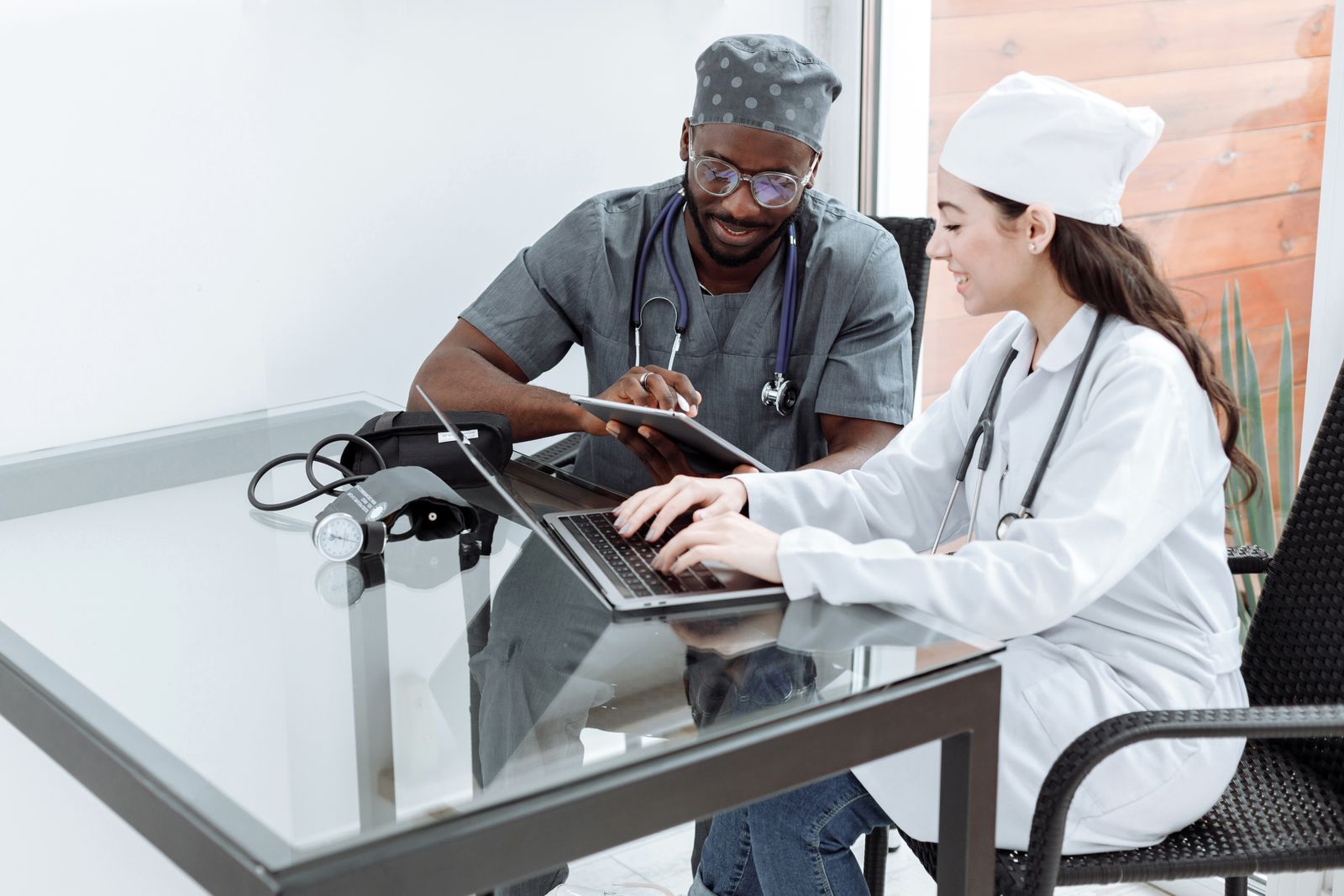 Doctor and nurse making a booking on a tablet and laptop